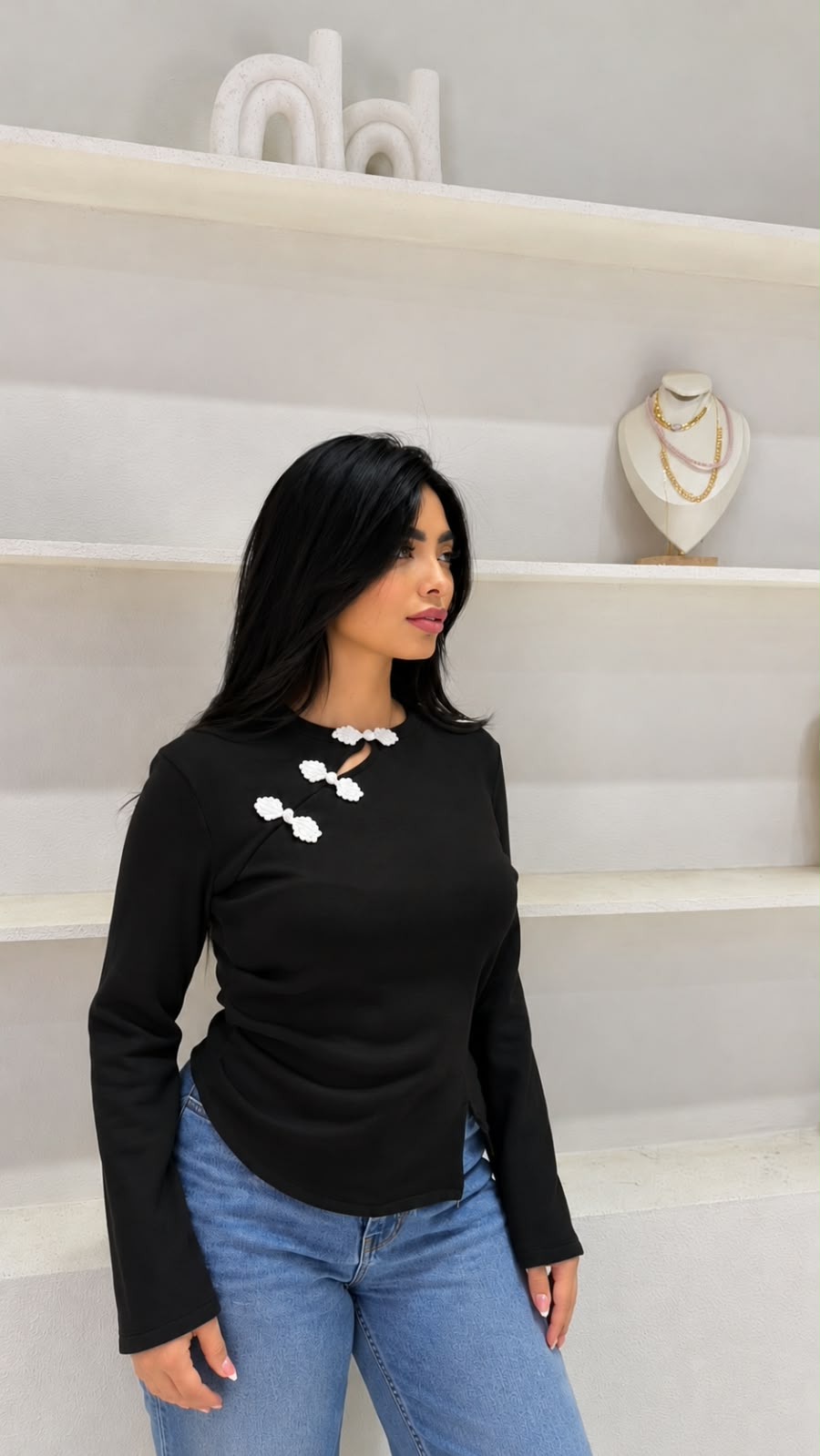 Long-sleeved knit top with an asymmetric button closure