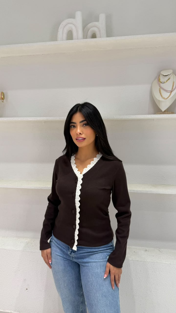 An elegant ribbed-knit cardigan, embellished with scalloped lace trim.
