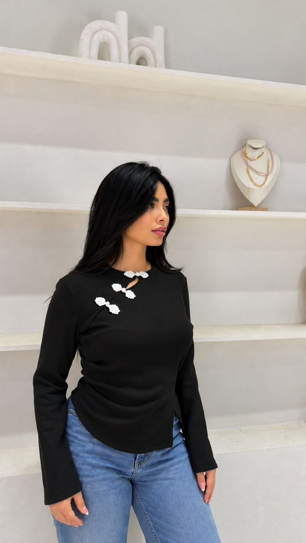 Long-sleeved knit top with an asymmetric button closure
