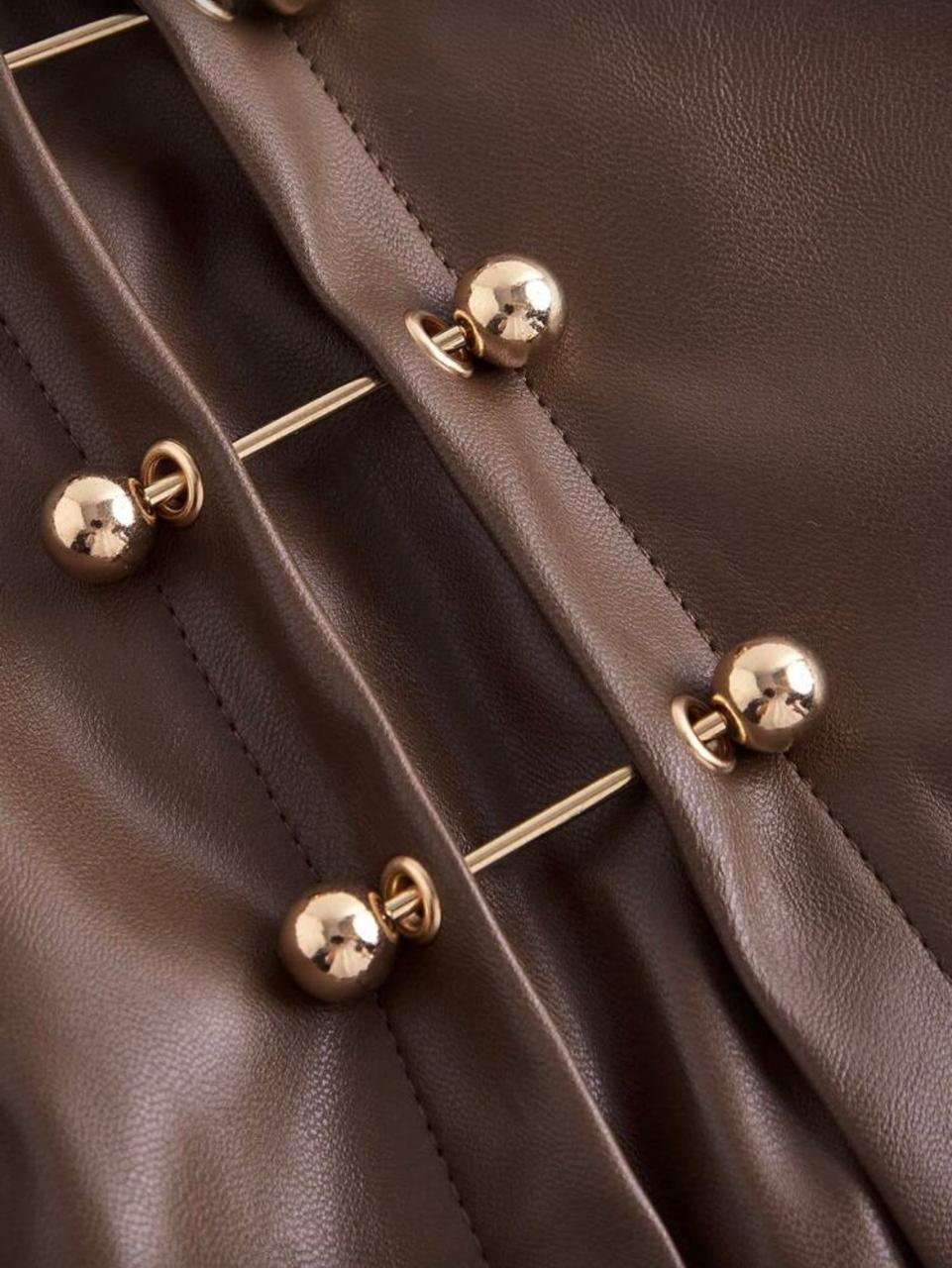 A short faux leather skirt with a high waist and gold-tone button slit detail.