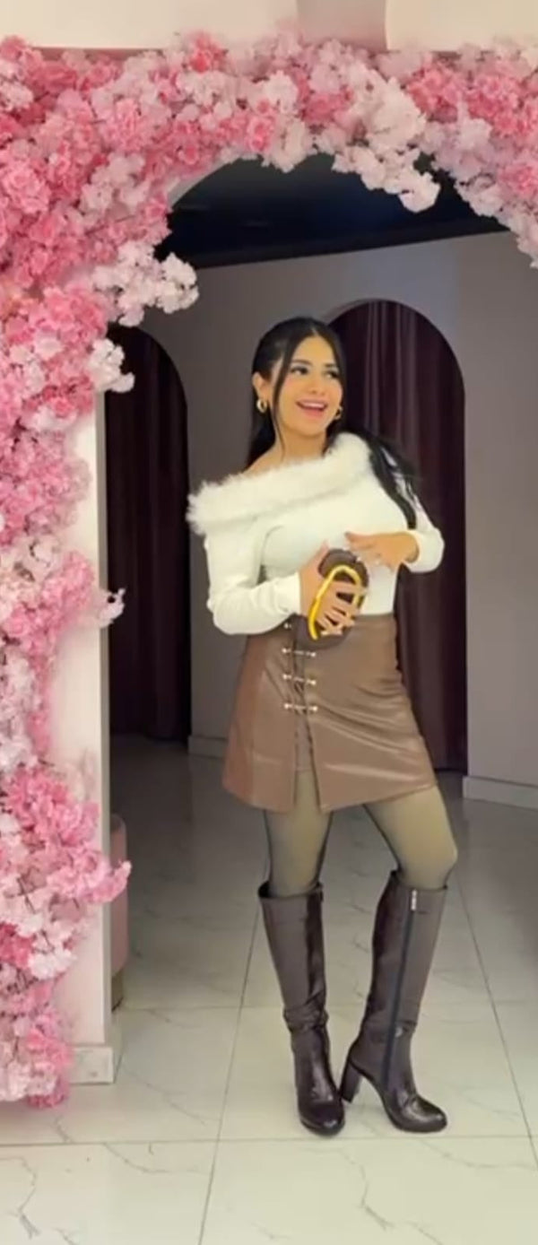 A short faux leather skirt with a high waist and gold-tone button slit detail.