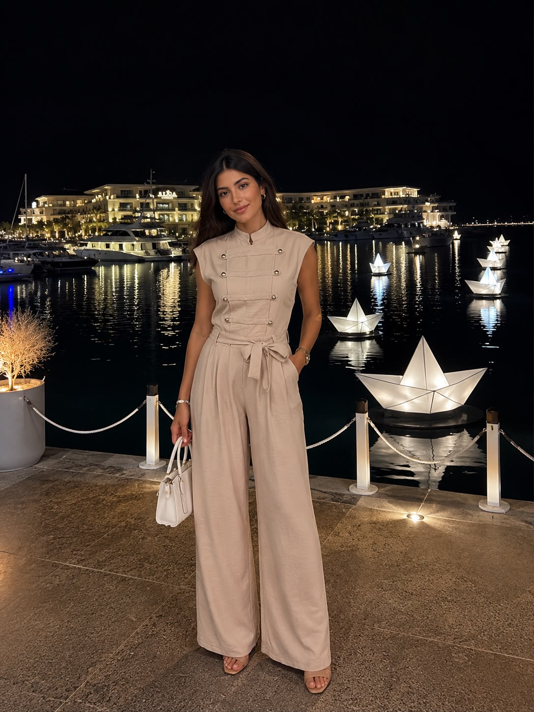 Elegant sleeveless double-breasted jumpsuit with a waist tie.